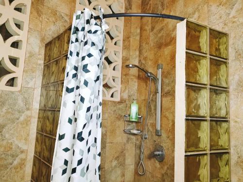 a shower with a shower curtain in a bathroom at Upani in Diani in Diani Beach