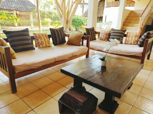 a living room with couches and a coffee table at Upani in Diani in Diani Beach