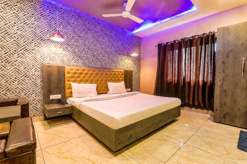 a bedroom with a bed in a room with purple lighting at FabHotel Rudra Inn & Cafe in Gorakhpur