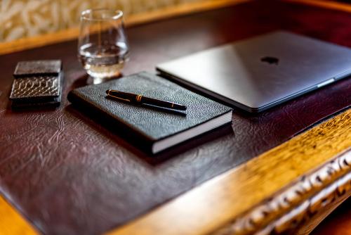 a pen on a notebook on a table with a laptop at Melville Castle Hotel in Edinburgh