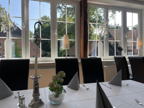 a meeting room with a table with chairs and windows at Dötlinger Hof in Dötlingen