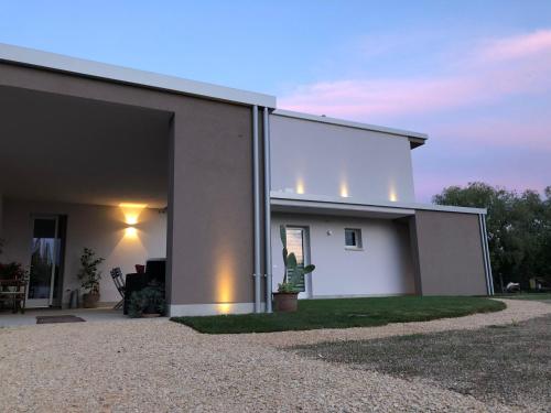 a white house with lights on the side of it at I Broletti del Garda in Pacengo di Lazise