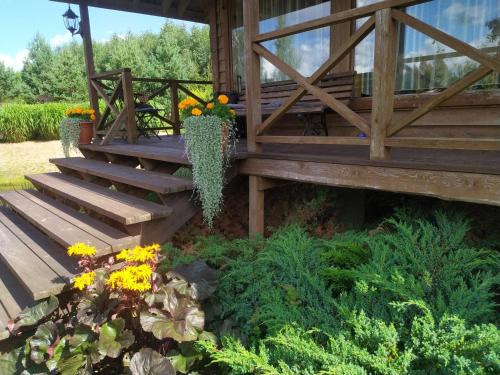 a wooden porch with stairs and flowers in a garden at Mikalojiškis in Inturkė