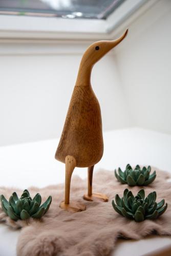 a toy animal standing on a table next to green plants at Hotel - B&B Elementum in Kortrijk