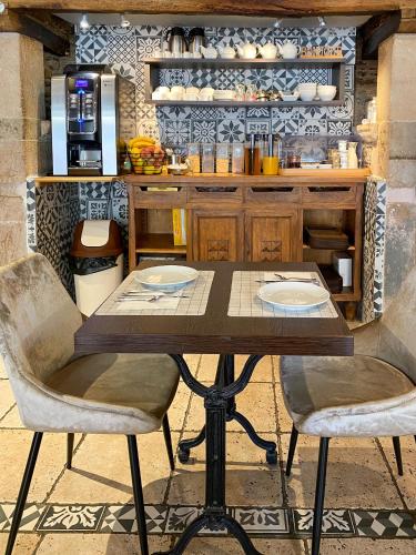 een houten tafel en stoelen in een keuken bij Hôtel Les Tilleuls de Pareloup à Salles-Curan in Salles-Curan