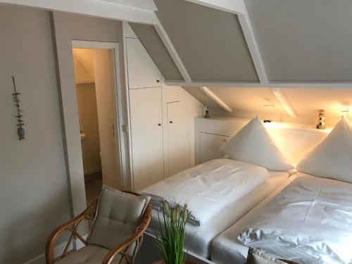 ein kleines Schlafzimmer mit einem Bett und einem Stuhl in der Unterkunft Silwai OG in Westerland