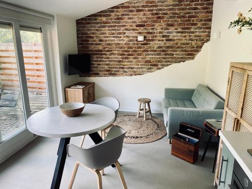a living room with a table and a brick wall at Overnachting Vanjewelste in Enschede