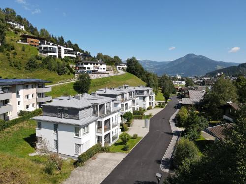 a row of houses on a hill with a road at Finest Apartments Glacier View by All in One Apartments in Kaprun