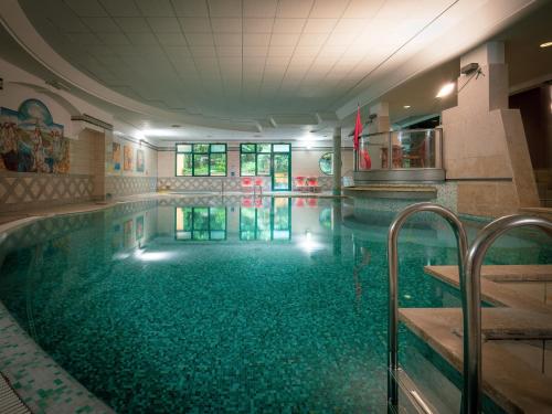 a large swimming pool with a green tile floor at Parc Hotel Gritti in Bardolino