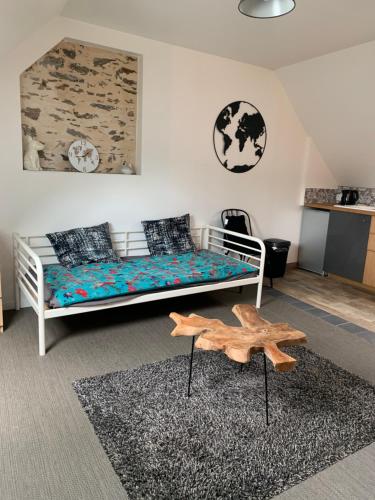 a bedroom with a bed and a table in a room at appartement belhommet 4 in Landerneau