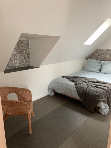 a bedroom with a bed and a chair at appartement belhommet 4 in Landerneau