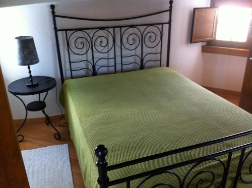 Un dormitorio con una cama y una lámpara sobre una mesa. en Moinho do Roque, en Lourinhã