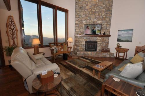 a living room with couches and a stone fireplace at The Crest 200C condo in Sugar Mountain