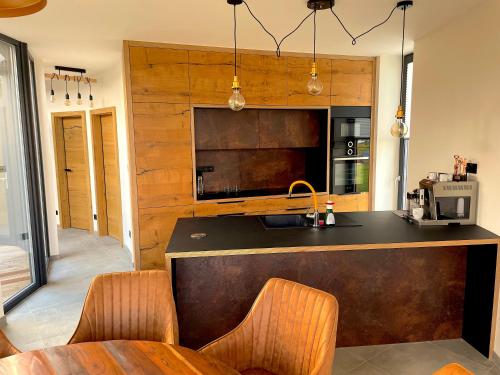 a kitchen with a counter with chairs and a sink at Panorama Kořenec in Kořenec