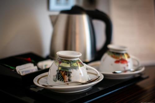 two dishes and a tea kettle on a table at Boutique Exclusive B&B in Trento