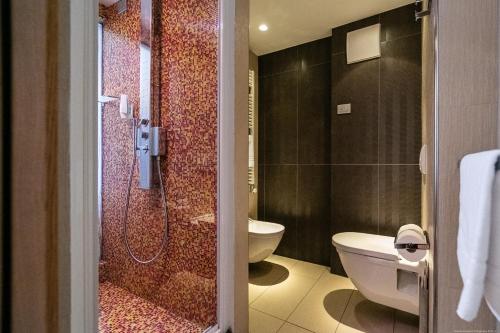 a bathroom with a shower and a toilet and a sink at Boutique Exclusive B&B in Trento
