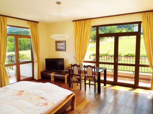 a bedroom with a bed and a table and chairs at Стаи за Гости Lavender Lozen in Lozen