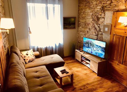a living room with a couch and a flat screen tv at Kohtu Apartment Epoch in Kuressaare