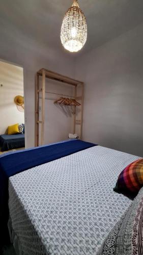 1 dormitorio con cama y lámpara de araña en Formosinha, en Baía Formosa