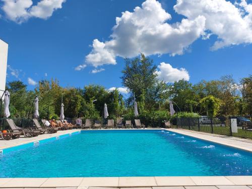 une piscine avec chaises et parasols dans l'établissement Atria Urban Resort, à Bucarest