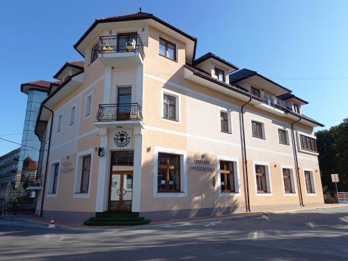 a large white building with a clock on it at Hotel Vyšehrad in Turčianske Teplice