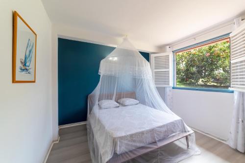 1 dormitorio con 1 cama con dosel en Villa Ti'Kemy avec piscine au sel en Le Lamentin