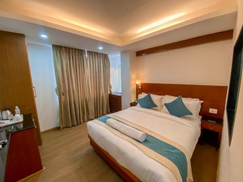 a hotel room with a large bed with blue pillows at Hotel Tradition & Spa in Kathmandu