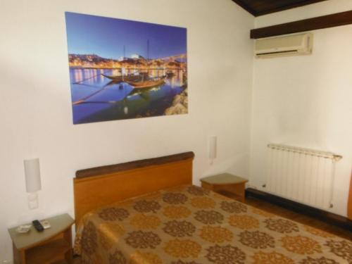 a bedroom with a bed and a painting on the wall at Hotel Alameda in Albergaria-a-Velha