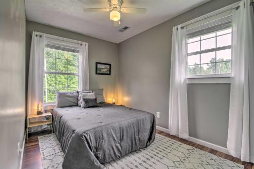 a bedroom with a bed and two windows at Stylish Fort Payne Retreat Hike and Rock Climb in Fort Payne