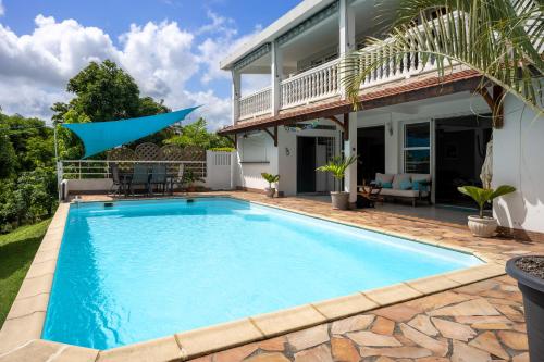 a swimming pool in the backyard of a home with a house at Villa Ti'Kemy avec piscine au sel in Le Lamentin