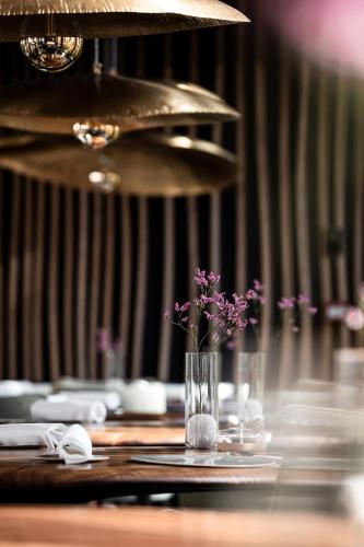une table avec un vase avec des fleurs violettes sur lui dans l'établissement Maison Aribert, à Saint-Martin-dʼUriage