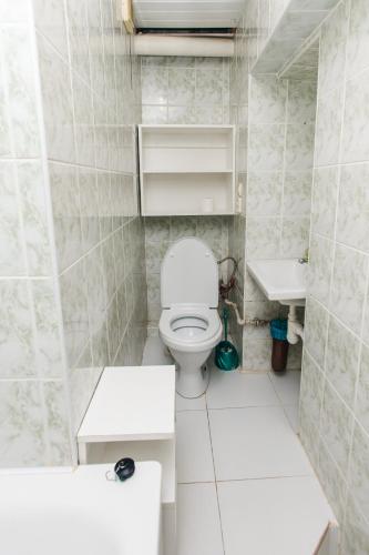 a white bathroom with a toilet and a sink at Mary in Lviv