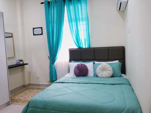 una camera da letto con un letto con cuscini blu e viola di Homestay Farah Tiara Duta Kondominium Ampang Selangor ad Ampang