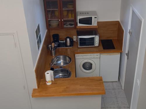 a small kitchen with a microwave and a washing machine at STUDIO PROCHE PARIS ET DISNEYLAND PARIS in Champigny-sur-Marne