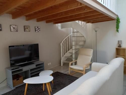 a living room with a tv and chairs and a staircase at STUDIO PROCHE PARIS ET DISNEYLAND PARIS in Champigny-sur-Marne