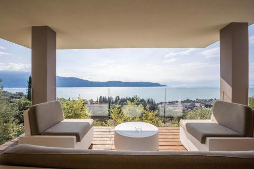 a living room with two chairs and a view of the water at Villa Agave exclusive pool in Toscolano Maderno