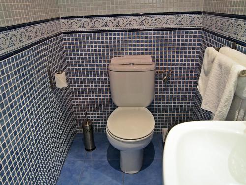 a bathroom with a white toilet and blue tiles at Hostal Fantoni in Cádiz
