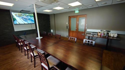 une salle de conférence avec une grande table et des chaises en bois dans l'établissement Hotel Guossi, à Karigasniemi