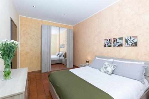 1 dormitorio con 1 cama grande y un jarrón de flores en Casa Cavour a pochi passi da Piazza San Carlo en Turín