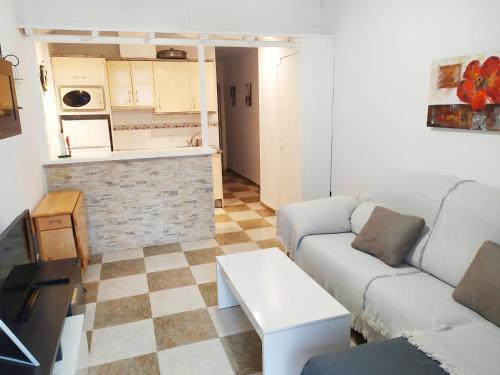 ein Wohnzimmer mit einem Sofa und einem Tisch in der Unterkunft Apartamento Carvajal Beach in Fuengirola