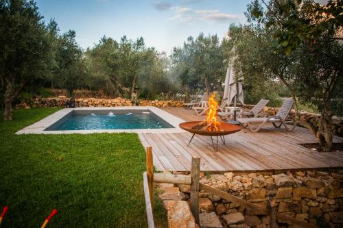 a fire pit on a wooden deck next to a pool at Casa do Manel in Trancoso
