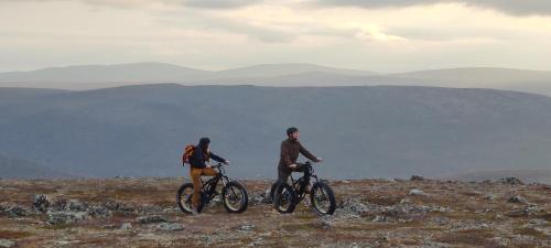 two people riding bikes on a mountain side at Hotel Guossi in Karigasniemi
