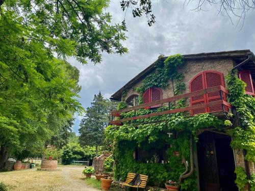 a building covered in ivy with benches in front of it at Agriturismo La Selva in Siena