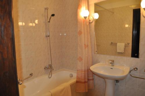 y baño con lavabo, aseo, bañera y lavamanos. en Hotel "Zajazd Napoleoński", en Varsovia