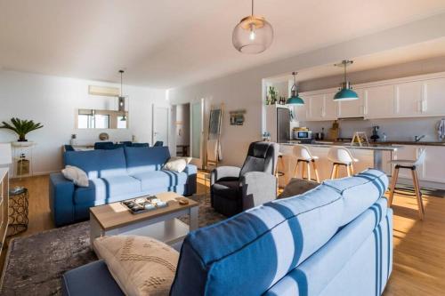 a living room with blue couches and a kitchen at Matriz Sunset View in Ribeira Grande