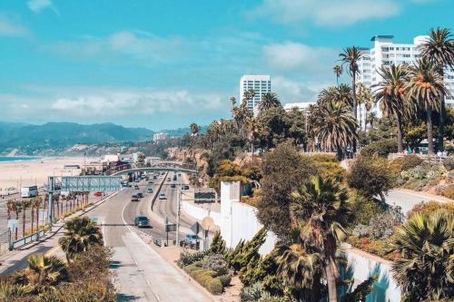 a view of a beach with palm trees and a road at 10 Cozy apartment heart of Santa Monica in Los Angeles