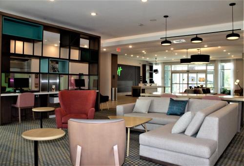 a living room with a couch and chairs and a kitchen at Holiday Inn - Fort Worth - Alliance, an IHG Hotel in Fort Worth