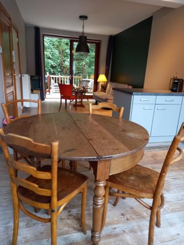 a dining room table with chairs and a kitchen at Le vieux Spa de Polo-Jo in Spa