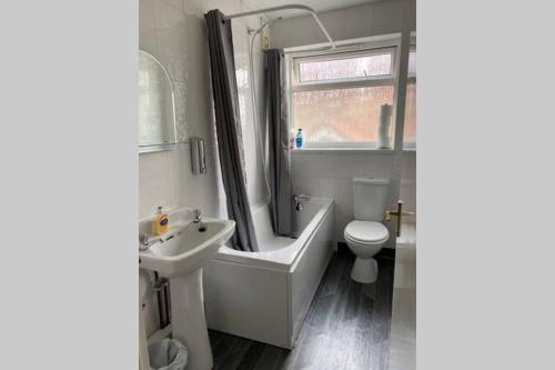 a bathroom with a tub and a sink and a toilet at Glen View a Stones Throw away from The Gower! in Swansea