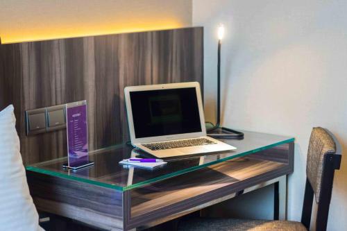 a desk with a laptop computer on top of it at Aqueen Hotel Paya Lebar in Singapore